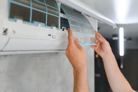 A person is replacing an ail filter