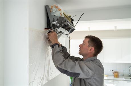 a technician is repairing an AC unit