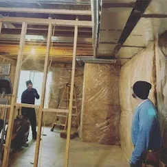 Top HVAC Energy Saving Tips for Homeowners 3 Workers applying insulation in a home, illustrating the importance of proper insulation for energy efficiency