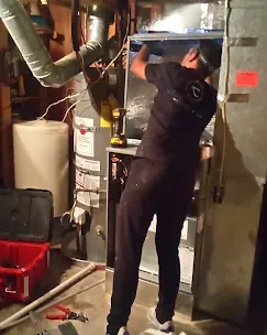 Spring & Fall HVAC Seasonal Check-ups 6 Technician inspecting a furnace for fall HVAC maintenance